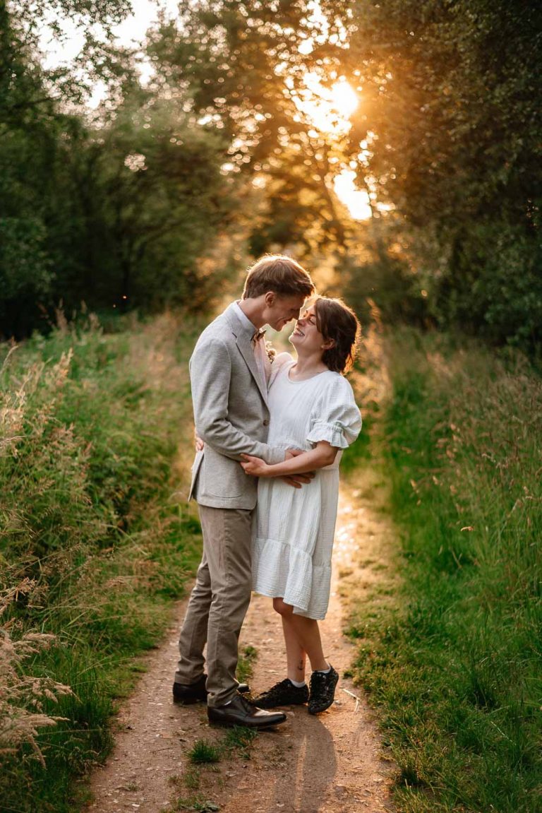 Brautpaar im Moor. Sie schauen sich liebevoll an. Die Sonne geht im Hintergrund runter.