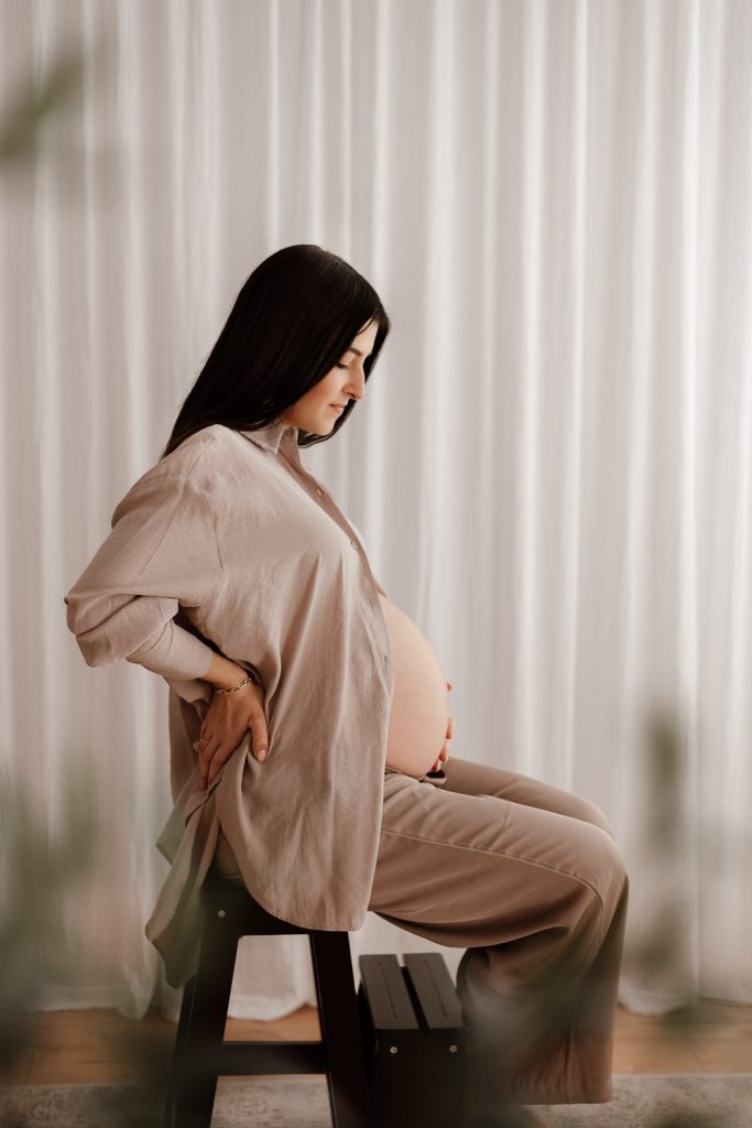 Babybauchshooting in der Nähe von Neumünster im Studio mit warmen Farbtönen.